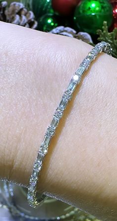 Glamour meets elegance with our 1.74ct tw diamond baguette and round alternating bracelet. Alternating diamonds in both baguette and round cuts create a stunning and unique design. Bring luxury to any outfit and make a statement with this beautiful piece. Metal: 18K White GoldDiamond Shape , Weight: (82) Round Cuts 1.89ctw, (54) Baguette Cuts 2.08ctwDiamond Total Weight: 3.97ct twBangle/Wrist Width: 53mm x 45mmBangle Width: 7mm Diamond Bracelet Design, Diamond Baguette, Baguette Cut, Baguette Diamond, Bracelet Designs, Round Cut, Diamond Bracelet, Unique Design, Unique Designs