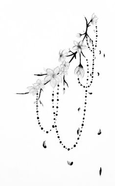 a black and white photo of flowers on a branch with beads hanging from it's end