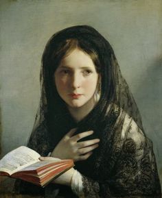 an old photo of a woman wearing a veil and holding a book in her hands