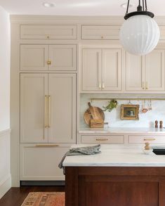 a large kitchen with white cabinets and wooden counter tops, along with an area rug on the floor