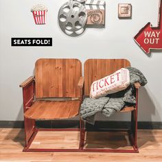 two wooden chairs sitting next to each other in front of a wall with movie memorabilia on it