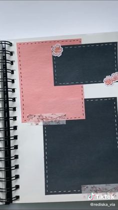 an open notebook with pink and black paper