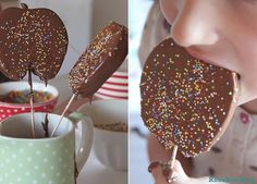 a girl eating a chocolate heart lollipop with sprinkles on it