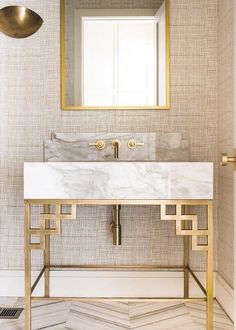 a bathroom with a marble sink and gold fixtures