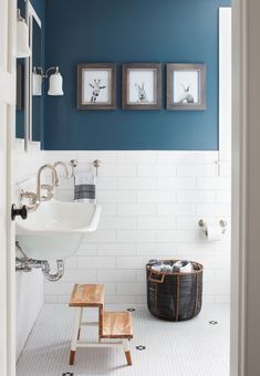 a bathroom with blue walls and white tiles on the floor, along with a wooden step stool