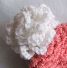 two crocheted pieces of pink and white yarn are on top of each other