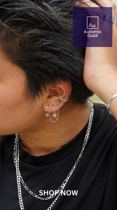 a man with black hair and silver jewelry on his neck, wearing an ear chain