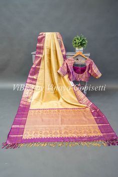 This royal and festive Light Pistachio Green And Purple Kanchi Silk Saree With Blouse features a stunning purple border with intricate gold zari work and comes with a matching blouse with work sleeves. Perfect for traditional occasions, the delicate tassels add a touch of elegance to this timeless piece. Made from high-quality silk, this saree is sure to make you stand out with its luxurious feel.. Traditional Gold Tissue Silk Choli, Transitional Gold Tussar Silk Blouse Piece, Gold Dola Silk Blouse Piece With Zari Weaving, Gold Handloom Dola Silk Blouse Piece, Gold Tussar Silk Choli With Dupatta, Gold Silk Sets For Puja, Purple Handloom Dola Silk Traditional Wear, Purple Handloom Traditional Wear In Dola Silk, Transitional Season Gold Lehenga In Tussar Silk