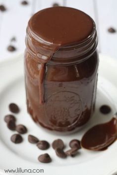 a jar of chocolate spread on a plate with coffee beans