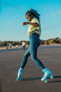 a young woman riding roller skates across a parking lot