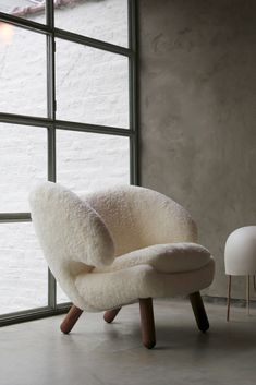 a white chair sitting in front of a window