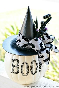 a decorated pumpkin with a black hat and bow on it's head that says boo