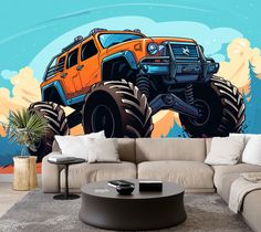 a living room with a couch and large monster truck mural on the wall