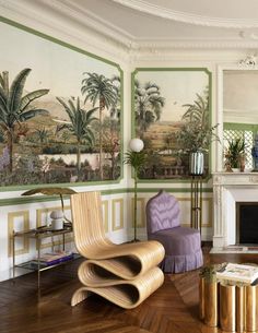 a living room filled with lots of furniture and paintings on the wall above it's fireplace