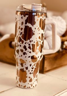 a white and brown coffee cup sitting on top of a counter