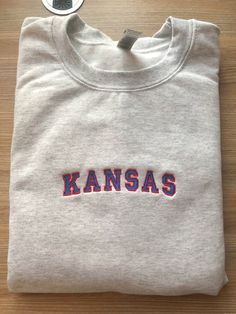 If you want a custom order or have any questions, please message me! -Kansas embroidered crewneck -50/50 cotton/polyester -Unisex sizing: fits true to size. Order one size up for a looser fit. Game Day T-shirt With Embroidered Logo, College Crew T-shirt With Embroidered Text, Custom Embroidery Crew T-shirt For College, Custom Embroidered Crew T-shirt For College, Collegiate Embroidered Cotton T-shirt, College Crew T-shirt With Custom Embroidery, Team Spirit Embroidered Cotton Sweatshirt, Cotton Team Spirit Sweatshirt With Custom Embroidery, Custom Embroidery Crew Neck T-shirt For College