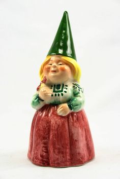 a ceramic gnome figurine sitting on top of a red potted planter