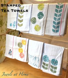 towels are hanging on the wall in front of a towel rack with tea towels and lemons