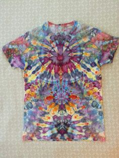 a colorful tie - dyed t - shirt is displayed on a white surface with an intricate pattern