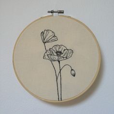 a white wall with a black and white flower embroideryed on it