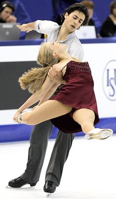 two people are skating on an ice rink