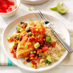 a white plate topped with rice, beans and vegetables next to a bowl of salsa