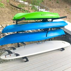 three surfboards are stacked on top of each other in front of a body of water