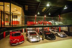 a group of cars parked inside of a garage next to each other in front of a staircase