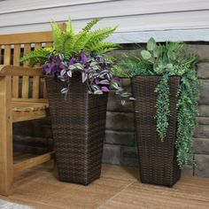 two planters sitting next to each other near a bench