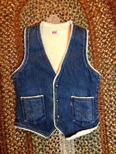 Amazing late 70's early 80's Levis denim vest with sherpa lining  Snap buttons  Darker denim  2 front pockets  Amazing vintage condition  Tag reads size small  Fits like a small  Measurements taken flat so please double bust and waist for more accurate sizing  Bust: 18 in Waist: 16.5 in  Length: 23.5 in  All sales are final  Disclaimer: I wear patchouli burn incense palo santo and sage  if you are scent sensitive I would not buy from my shop. My Etsy space is in its own space in our basement but Vintage Sleeveless Winter Vest, Rugged Fitted Vest Outerwear, Retro Fitted Winter Vest, Fitted Sleeveless Rugged Outerwear, Vintage Cotton Vest Outerwear, Fitted Denim Vest With Pockets For Winter, Fitted Winter Denim Vest With Pockets, Winter Fitted Denim Vest With Pockets, Fitted Western Vest For Winter