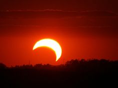 the sun is setting in front of an eclipse