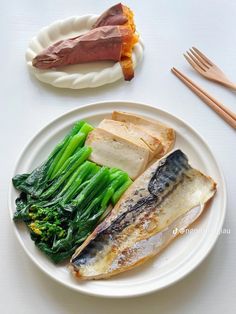 a white plate topped with fish and vegetables