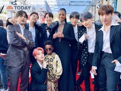 a group of people standing on top of a red carpet