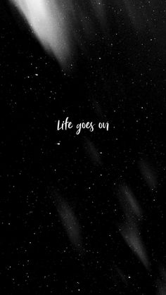 the words life goes on written in black and white against a dark background with stars