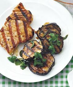 three grilled meats on a white plate with green garnish and cilantro