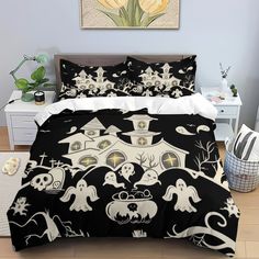 a bed covered in black and white halloween themed comforters