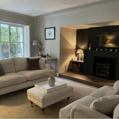 a living room filled with furniture and a fire place in front of a large window