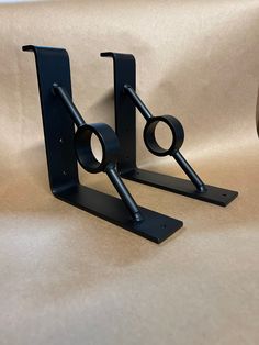 two black metal bookends sitting on top of a table