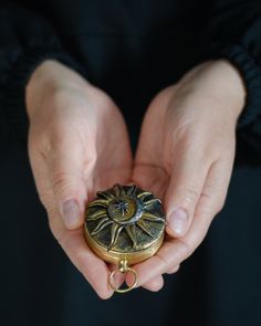 a person holding an antique pocket watch in their hands with the clock on it's side