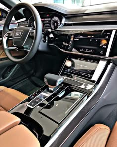 the interior of an audi car with brown leather seats and dashboard controls, including electronic devices