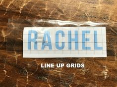 a sticker that says rachel on it sitting on top of a piece of wood