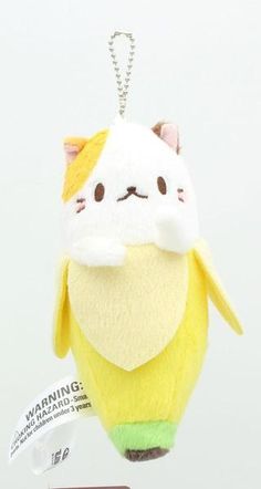 a yellow and white stuffed animal keychain hanging from a metal chain with a tag attached to it