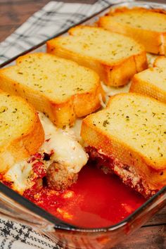 a casserole dish filled with meat, cheese and tomato sauce on top of a checkered cloth