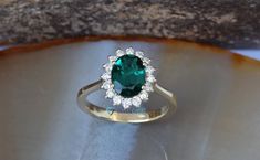 a ring with a green stone surrounded by white diamonds