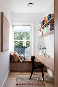 a window seat in the corner of a room with bookshelves on either side