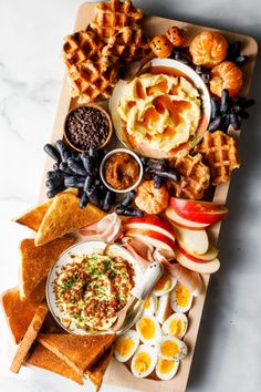 a wooden tray topped with different types of food and desserts on top of it