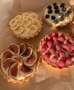 four pies with different toppings are arranged on a table