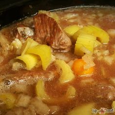 a stew with meat, potatoes and carrots in a crock pot