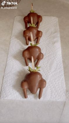 chocolate candies are arranged in the shape of three bears on a white towel with bamboo sticks sticking out of them