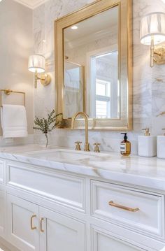 a bathroom with marble counter tops and gold accents